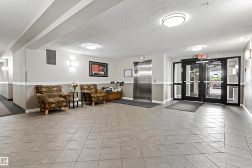 Welcoming lobby featuring polished tile flooring, recessed ceiling lighting, and stainless steel elevator access - #305A 6 Spruce Ridge Dr, Spruce Grove, AB - Indoor
