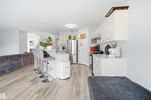 Kitchen with white cabinetry, stainless steel appliances, and light-toned countertops - 714 87 Street Sw, Edmonton, AB - Indoor Photo Showing Kitchen