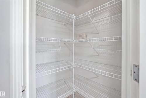 Corner pantry featuring white wire shelving, multiple storage levels, and integrated wire baskets - 714 87 Street Sw, Edmonton, AB - Indoor With Storage