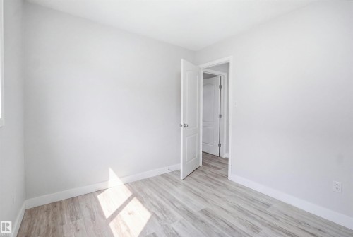 Room featuring light wood-finish flooring, white walls, and white baseboards - 714 87 Street Sw, Edmonton, AB - Indoor Photo Showing Other Room