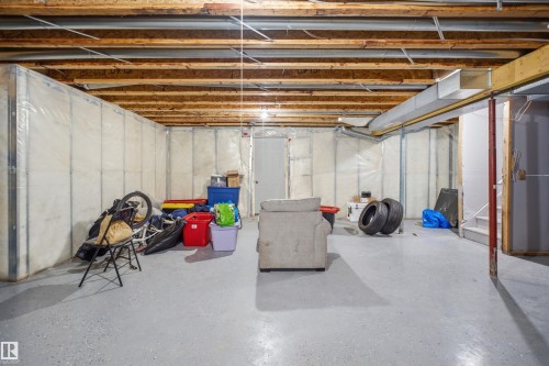 Unfinished basement featuring exposed wood joists, insulated perimeter walls, a concrete floor, and a clearly defined staircase - 714 87 Street Sw, Edmonton, AB - Indoor Photo Showing Basement