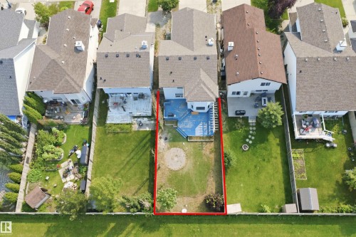 Expansive backyard featuring a multi-level deck with built-in stairs, a substantial green space, and mature perimeter trees - 714 87 Street Sw, Edmonton, AB - 