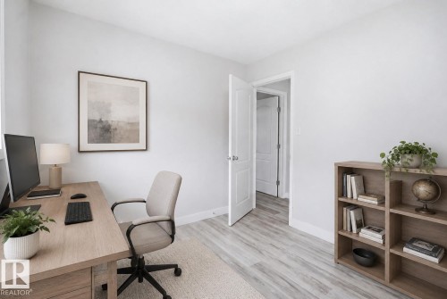 Neutral-toned room featuring a light wood-finish desk, light wood-finish shelving unit, white walls, and wood-finish flooring - 714 87 Street Sw, Edmonton, AB - Indoor Photo Showing Office