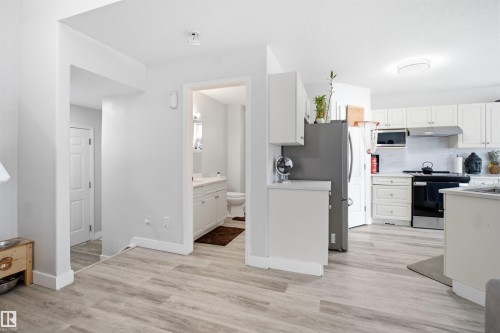 Open-concept living space with wood-finish flooring throughout - 714 87 Street Sw, Edmonton, AB - Indoor Photo Showing Kitchen