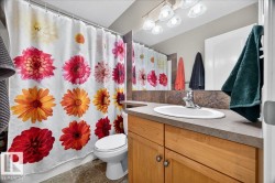 Vanity with integrated sink, wood-finish cabinetry, and brushed nickel hardware - 