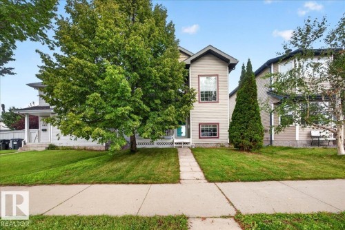 Two-story residence featuring neutral siding exterior, symmetrical facade with multi-pane windows, and a welcoming front entrance - 887 Oakland Boulevard, Devon, AB - Outdoor