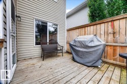 Spacious composite deck featuring horizontal wood-finish decking, accessible glass sliding doors, and wooden privacy fencing - 