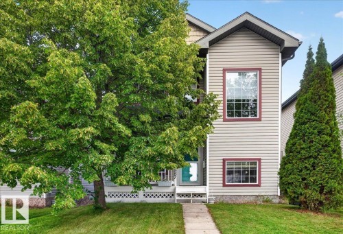 Vertical siding exterior with contrasting trim, multiple windows, and a paved walkway - 887 Oakland Boulevard, Devon, AB - Outdoor