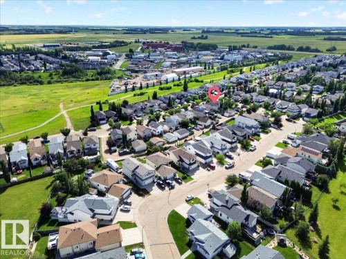 Aerial view showcasing a well-planned residential community featuring tree-lined streets, spacious individual lots with mature landscaping, and expansive green spaces throughout the neighborhood - 887 Oakland Boulevard, Devon, AB - Outdoor With View