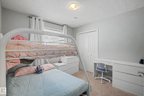 Bedroom featuring light gray walls, textured carpet, and a window with blinds - 21 Nash Close, St. Albert, AB - Indoor Photo Showing Bedroom