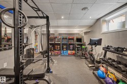 Spacious lower-level room featuring durable rubber flooring, recessed lighting, and a window providing natural light - 