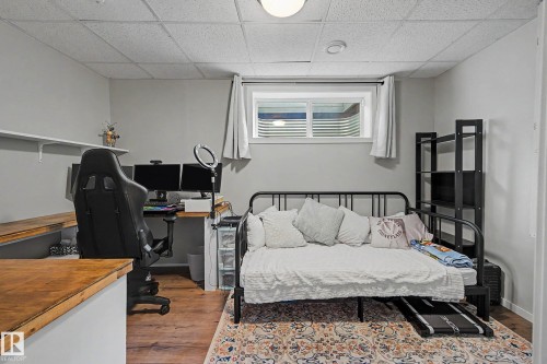 Versatile room featuring wood-finish flooring, a functional window, and a built-in wood countertop - 21 Nash Close, St. Albert, AB - Indoor Photo Showing Bedroom