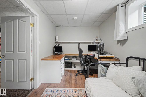 Dedicated workspace featuring wood-finish flooring, light gray walls, and built-in shelving - 21 Nash Close, St. Albert, AB - Indoor Photo Showing Office