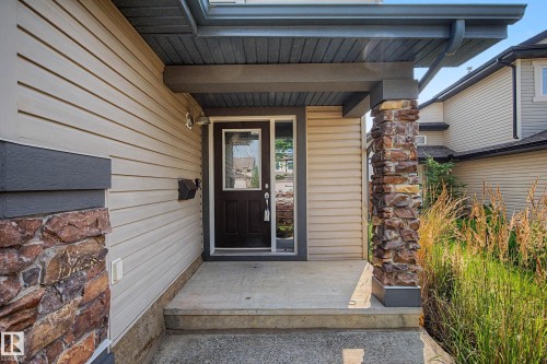 Covered front entry featuring a stone-clad column and concrete steps - 21 Nash Close, St. Albert, AB - Outdoor With Exterior