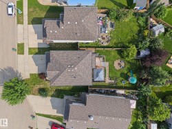 Expansive property featuring a large private backyard with mature trees, a dedicated deck space, and paved driveway - 