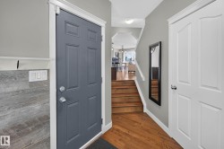 Entryway featuring a paneled door, wood-finish flooring, and a mirrored accent - 