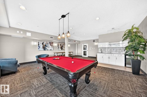 Recreational room featuring a pool table, patterned carpet flooring, recessed lighting, and a built-in wet bar with white cabinetry - #238 1008 Rosenthal Bv Nw, Edmonton, AB - Indoor Photo Showing Other Room