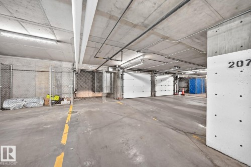 Concrete flooring with yellow directional markings - #238 1008 Rosenthal Bv Nw, Edmonton, AB - Indoor Photo Showing Garage