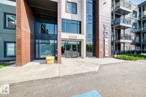 Modern building exterior featuring large windows, wood-finish siding, and multiple balconies - #238 1008 Rosenthal Bv Nw, Edmonton, AB - Outdoor With Balcony With Facade
