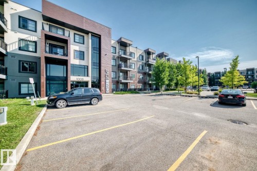 Modern residential complex featuring a contemporary multi-unit building with mixed material facade in white, charcoal, and warm brick tones - #238 1008 Rosenthal Bv Nw, Edmonton, AB - Outdoor With Balcony With Facade