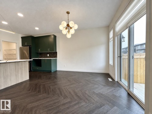 Open-concept living area featuring rich wood-finish flooring in a herringbone pattern - 5478 Kootook Road Sw, Edmonton, AB - Indoor Photo Showing Kitchen
