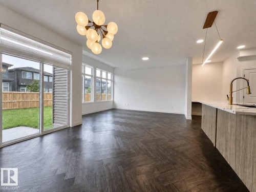 Open-concept living space with dark wood-finish flooring in a herringbone pattern - 5478 Kootook Road Sw, Edmonton, AB - Indoor