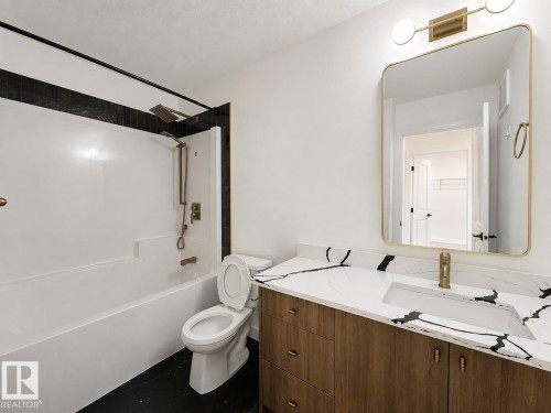 Bathroom featuring a wood-finish vanity with a white countertop and black veining, a rectangular undermount sink, and a gold-toned faucet - 5478 Kootook Road Sw, Edmonton, AB - Indoor Photo Showing Bathroom
