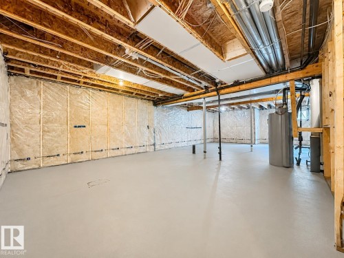Spacious unfinished basement featuring exposed wood joists, insulated walls, concrete flooring, and visible plumbing infrastructure - 5478 Kootook Road Sw, Edmonton, AB - Indoor Photo Showing Basement