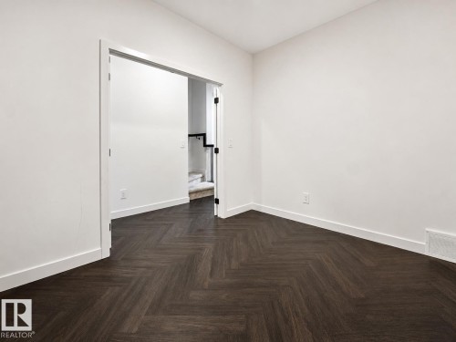 Room with dark wood-finish flooring laid in a herringbone pattern - 5478 Kootook Road Sw, Edmonton, AB - Indoor Photo Showing Other Room