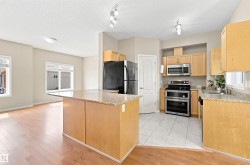 Kitchen featuring light wood cabinetry, countertops, stainless steel appliances, and tile flooring - 