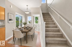 Light-filled dining area featuring wood-finish flooring and a contemporary pendant light fixture - 