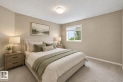 Carpeted bedroom featuring a large window with white blinds, a flush mount ceiling light, and neutral wall tones - 