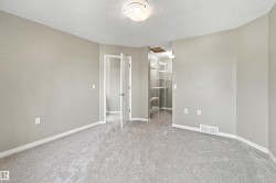 Spacious room with light gray carpeting, neutral wall finishes, and white baseboards - 