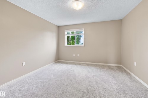 Neutral-toned room featuring a single window, light gray carpet, and a flush mount ceiling light fixture - #144 104 West Haven Dr, Leduc, AB - Indoor Photo Showing Other Room