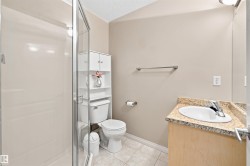 Full bathroom featuring a walk-in shower with glass enclosure, a single vanity with stone countertop, and tile flooring - 