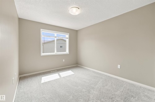 Light grey carpeting with matching baseboards and neutral wall paint - #144 104 West Haven Dr, Leduc, AB - Indoor Photo Showing Other Room