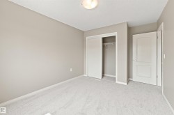 Neutral-toned room featuring light gray carpeting, white baseboards, and a semi-flush mount ceiling light - 