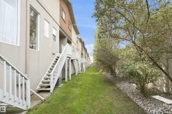 Rear exterior with a grassy expanse and a row of mature trees - 