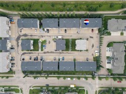 Residential development featuring multiple townhome-style buildings with dark grey roofs - 