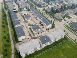 Aerial perspective of a developed residential community featuring rows of townhomes and detached properties - 