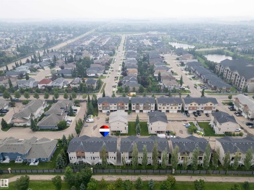 Aerial perspective showcasing a residential development with multi-story townhomes and detached residences - #144 104 West Haven Dr, Leduc, AB - Outdoor With View