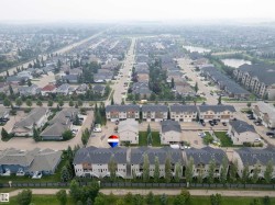 Aerial perspective showcasing a residential development with multi-story townhomes and detached residences - 