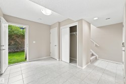 Tiled entryway featuring a double-door exterior access, an interior door, a sliding closet door, and a carpeted staircase - 