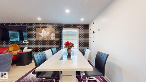 Dining area featuring a white rectangular table, recessed lighting, and a window with horizontal blinds - 12812 45 Street Nw, Edmonton, AB - Indoor Photo Showing Dining Room