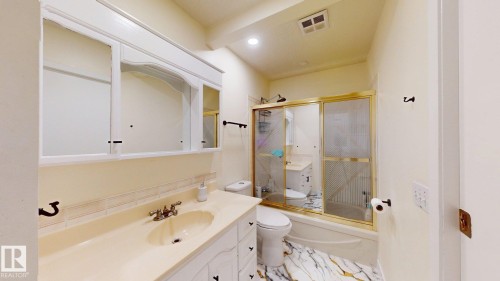 Bathroom featuring a vanity with integrated sink, white cabinetry, and an overhead mirrored medicine cabinet - 12812 45 Street Nw, Edmonton, AB - Indoor Photo Showing Bathroom