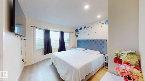 Bedroom featuring a bay window, light wood-finish flooring, and recessed ceiling lighting - 12812 45 Street Nw, Edmonton, AB - Indoor Photo Showing Bedroom