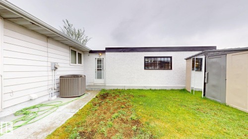 Exterior featuring white horizontal siding, a textured white stucco wall, and a concrete pathway - 12812 45 Street Nw, Edmonton, AB - Outdoor With Exterior