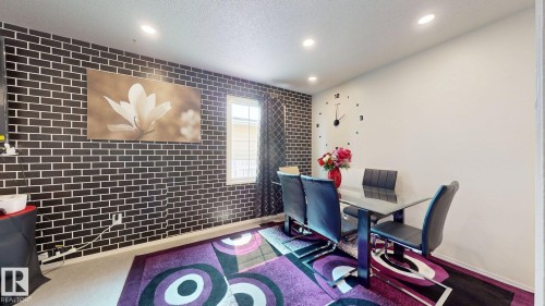 Dining area featuring recessed lighting, a window with vertical blinds, and a contrasting accent wall with a brick-pattern finish - 12812 45 Street Nw, Edmonton, AB - Indoor