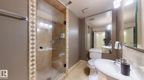 Glass-enclosed walk-in shower with decorative tile surround and recessed shelving - 12812 45 Street Nw, Edmonton, AB - Indoor Photo Showing Bathroom