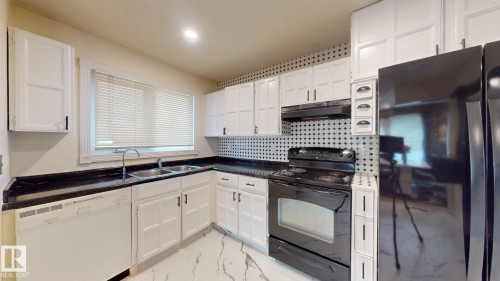 Kitchen featuring white cabinetry, black countertops, a black electric range, a black refrigerator, and a white dishwasher - 12812 45 Street Nw, Edmonton, AB - Indoor Photo Showing Kitchen With Double Sink
